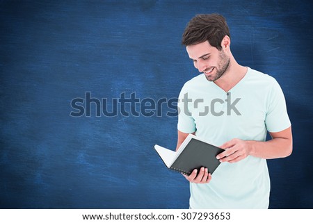 Student reading book against blue chalkboard