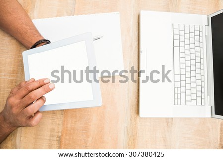Hands using blank screen tablet on wooden desk