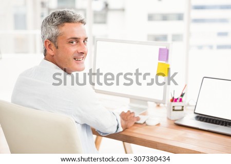 Portrait of smiling casual businessman working with computer in the office