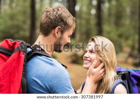 Young happy hiker couple looking at each other in the nature