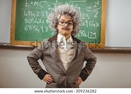 Portrait of little Einstein posing in front of chalkboard in a classroom