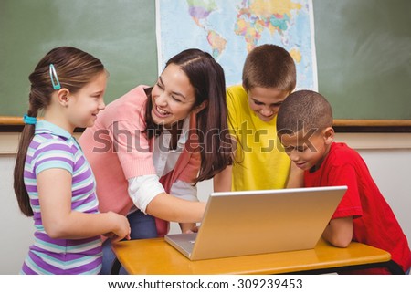 Students and teacher using a laptop at the elementary school