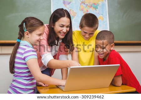 Students and teacher using a laptop at the elementary school