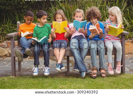 Children reading from books together while sitting down