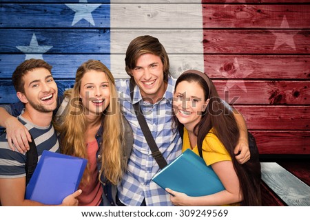 Students holding folders at college corridor against composite image of usa national flag