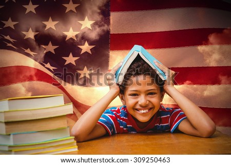Pupil with many books against composite image of digitally generated united states national flag