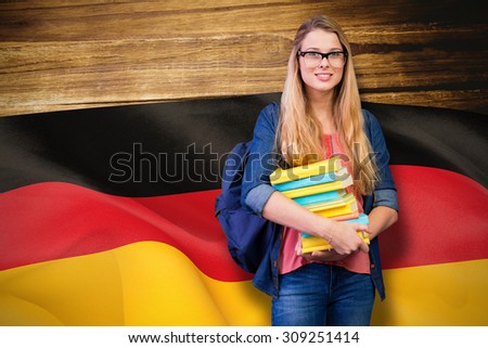 Pretty student in the library against digitally generated german national flag