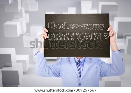 Businessman showing board against room with floating cubes