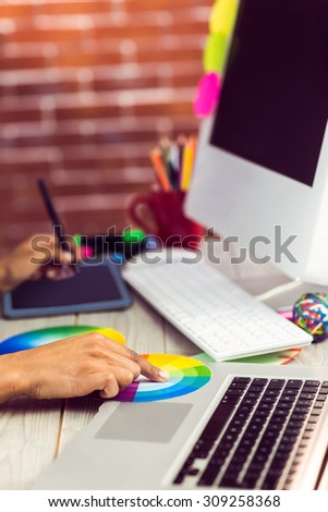 Graphic designer working with colour chart and digitizer at workplace