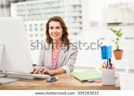 Portrait of smiling casual businesswoman working with computer in the office