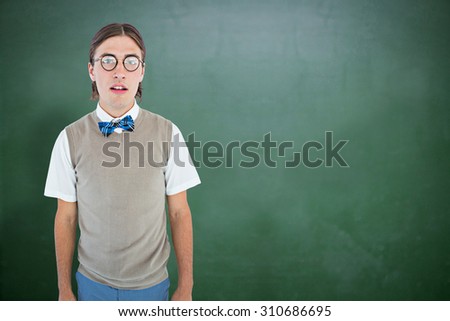 Geeky hipster looking at camera against green chalkboard