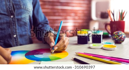 Graphic designer drawing on colour chart at workplace