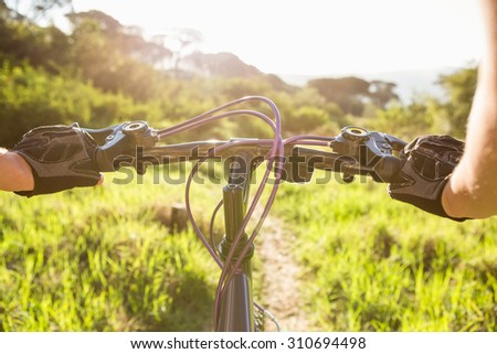 Woman mountain biking and holding handlebars in the nature