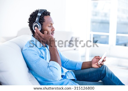 Man listening to music while sitting on sofa at home