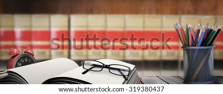 School supplies on desk against close up of big books