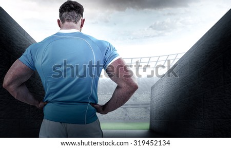 Rugby player with hands on hips against rugby stadium