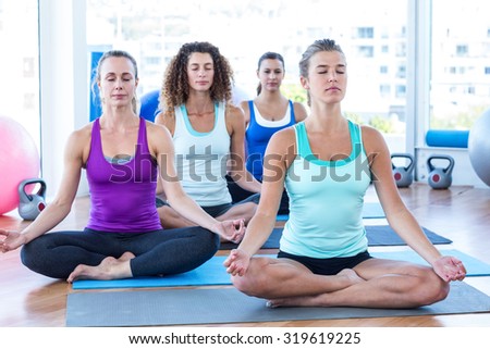 Focused women in fitness studio doing easy pose