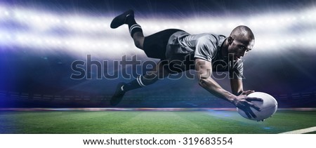 Sportsman jumping for catching rugby ball against rugby stadium