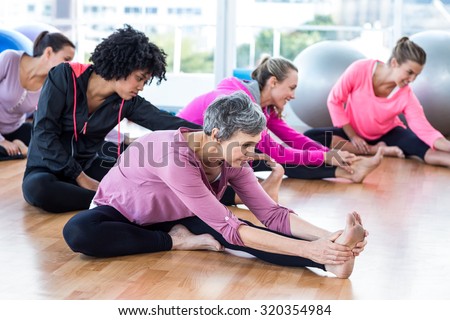 Fit women exercising on hardwood floor in fitness studio