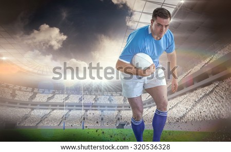 Rugby player doing a side pass against rugby stadium