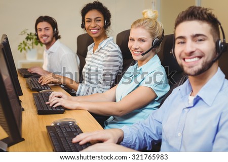Portrait of smiling executives working together in call center