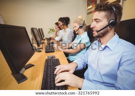 Executives working in call center wearing headsets