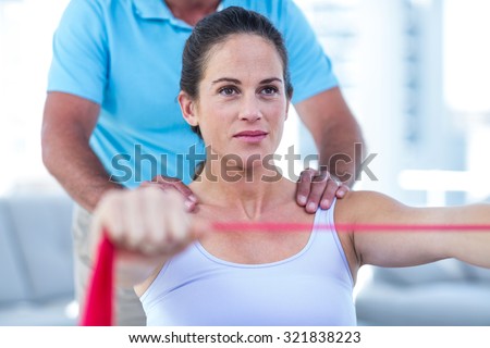 Focused pregnant woman stretching exercise band