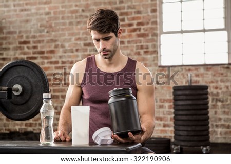 Man holding supplement tin at the gym