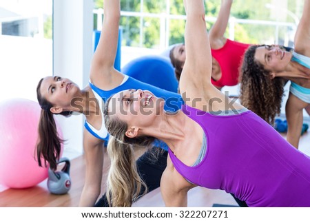 Cropped image of women doing side stretch in fitness studio