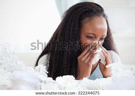 Close up of woman blowing her nose against used tissues