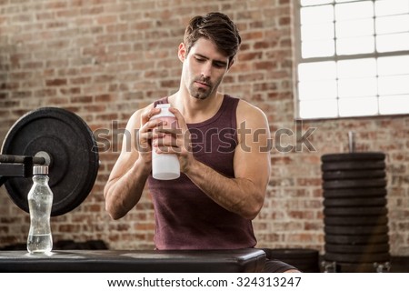 Man shaking shaker bottle at the gym