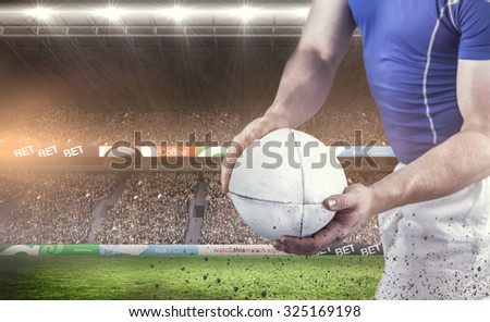 Rugby player about to throw the rugby ball against rugby fans in arena