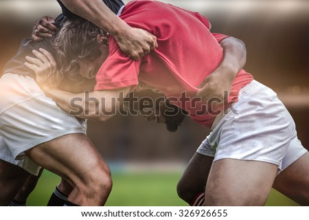 Rugby fans in arena against rugby players doing a scrum