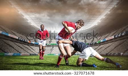 Rugby stadium against rugby players tackling during game