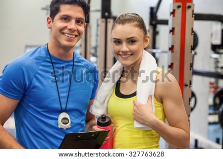 Trainer and woman discussing workout plan at the gym