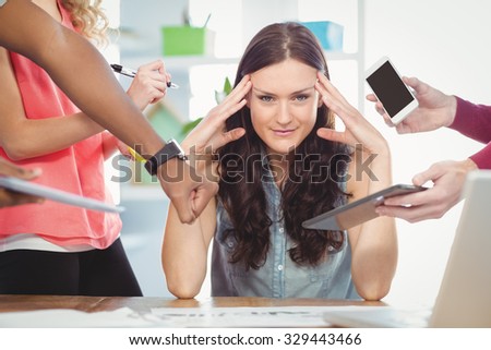 Woman with head in hands while sitting at desk