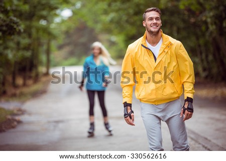 Happy couple roller blading together in the countryside