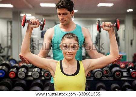 Trainer helping client work out at the gym