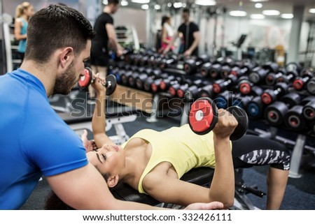 Fit people working out in weights room at the gym