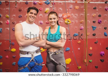 Fit couple at the rock climbing wall at the gym