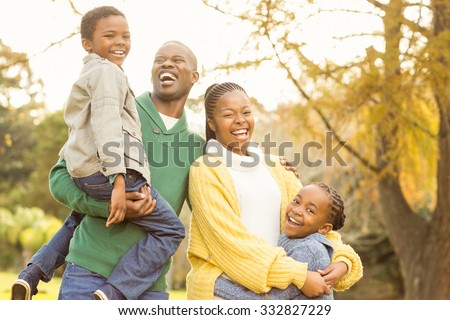 Portrait of a smiling young family laughing on an autumns day