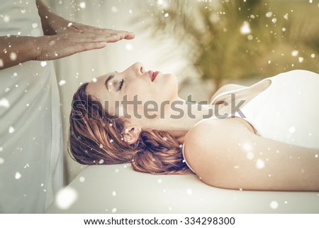 Snow against calm woman receiving reiki treatment