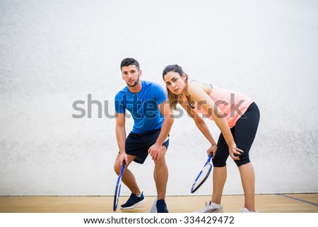 Couple tired after a squash game in the squash court