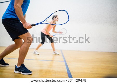 Woman about to serve the ball in the squash court