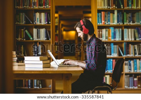 Hipster student studying in library at the university