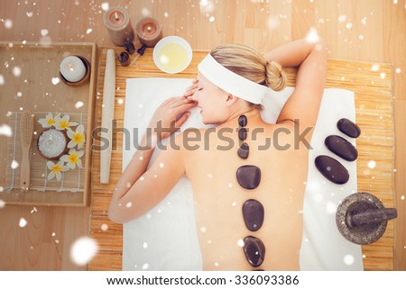 Snow against beautiful blonde enjoying a hot stone massage