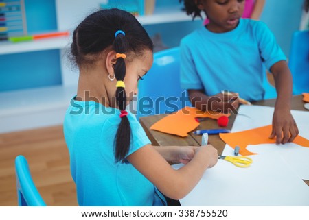 Happy kids enjoying arts and crafts painting at their desk