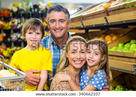 Smiling happy family posing together at supermarket