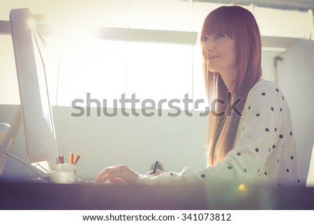Smiling using graphics tablet in her office