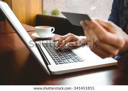 Student using laptop in cafe to shop online at the university